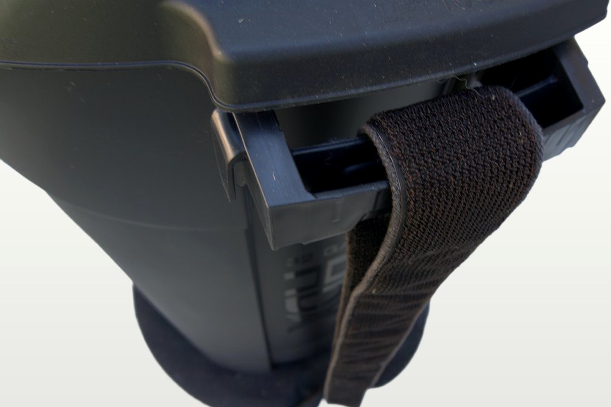 Detail view: the strap threaded through the trash can's side handle, with the CanClamp base visible underneath